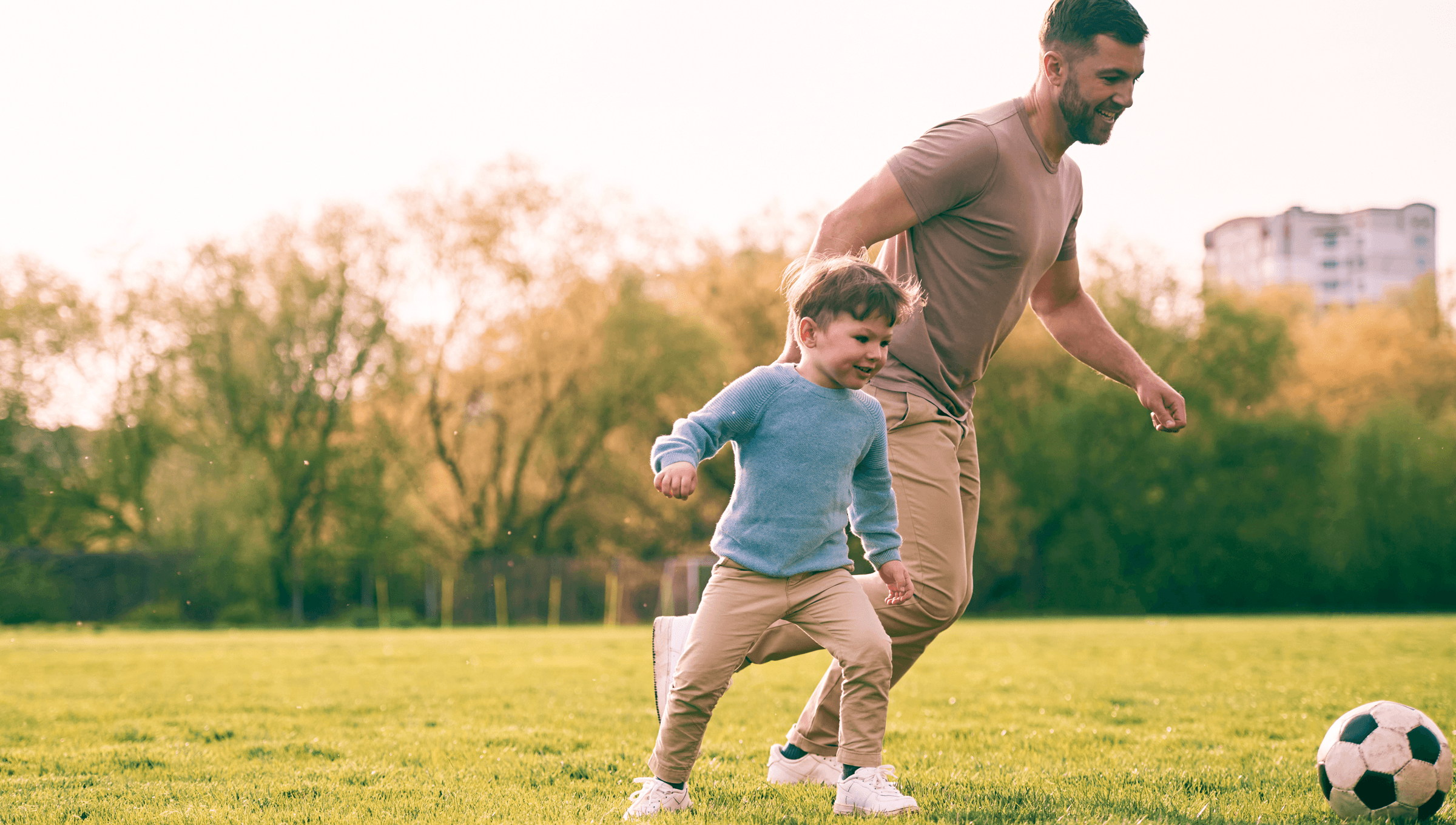 Father and son playing football in a park