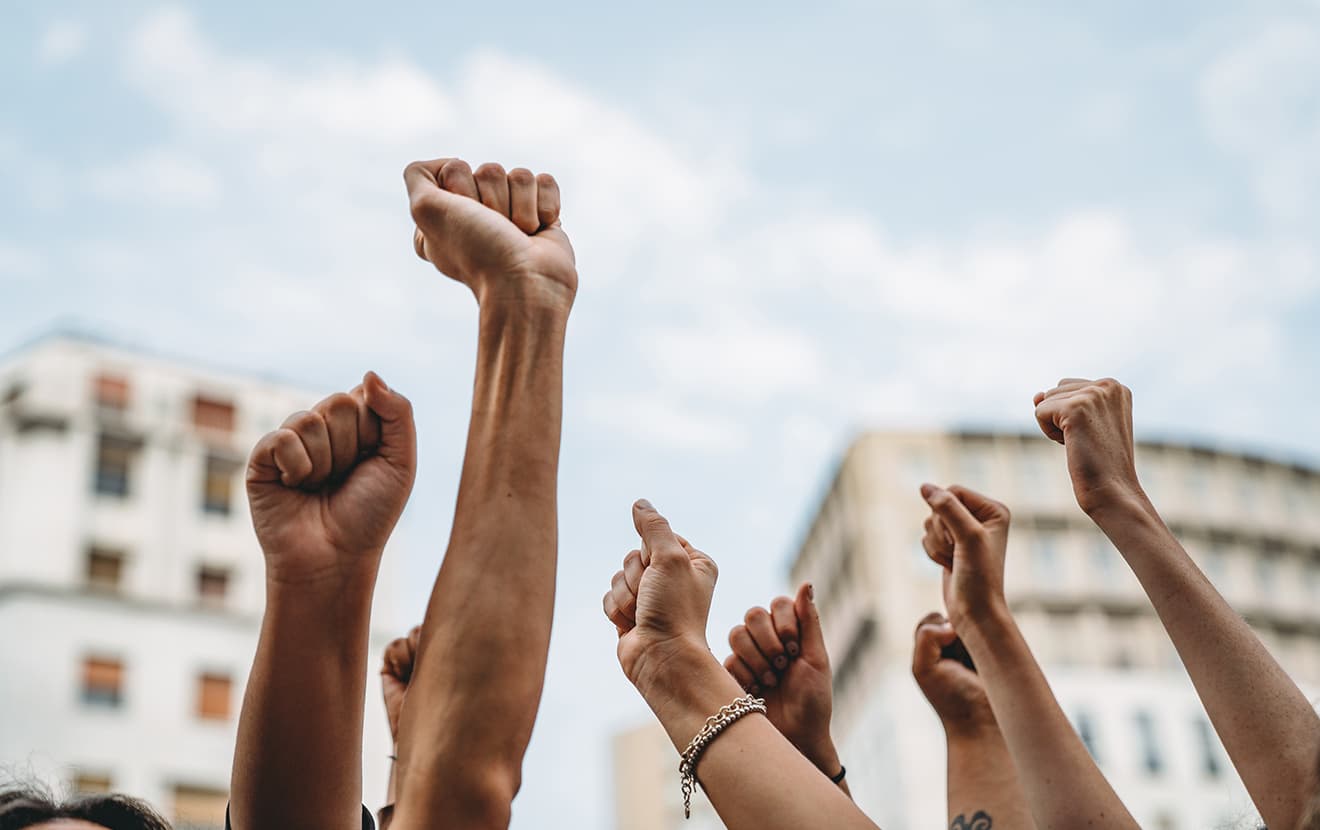 multicolored hands raised up in the air